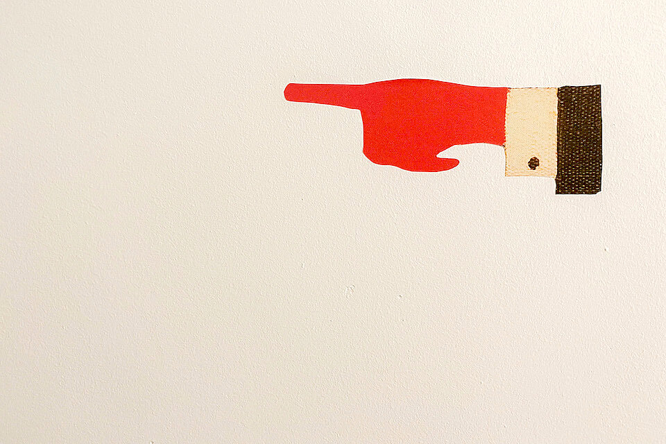 Illustration: rote Hand mit ausgestrecktem Zeigefinger nach rechts. Wird im Programmheft und auf der Website der VHS Eching als Gestaltungselement verwendet.